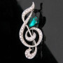 Broche Belons tendance en forme de note de musique/clé de sol avec strass et cristal vert en forme de goutte, pour femme
